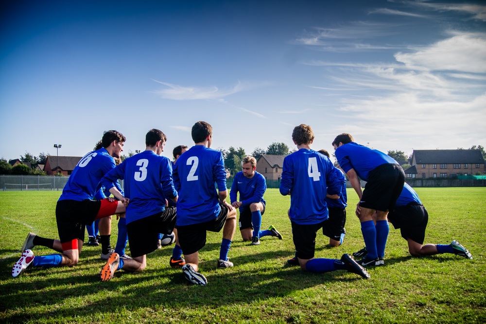 soccer players kneeling on the field